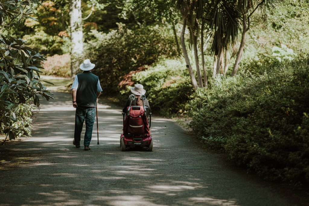 Zwei alte Menschen spazieren im Park.