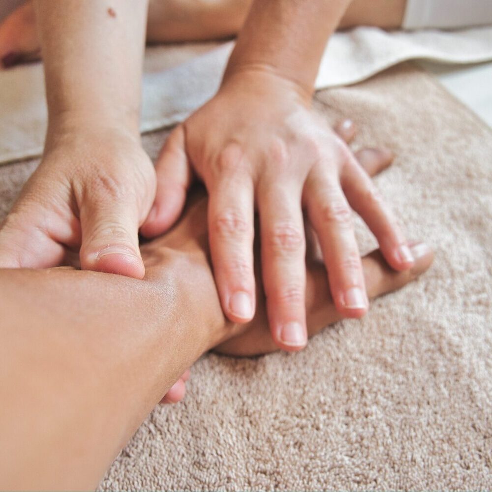 Therapeut:in führt Lymphdrainage am Arm aus