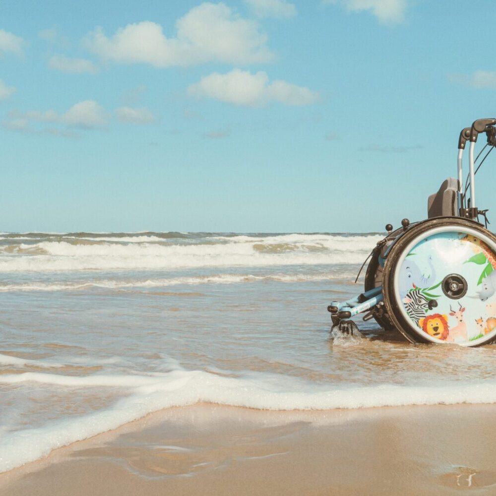 Ein leerer Kinderrollstuhl am Strand