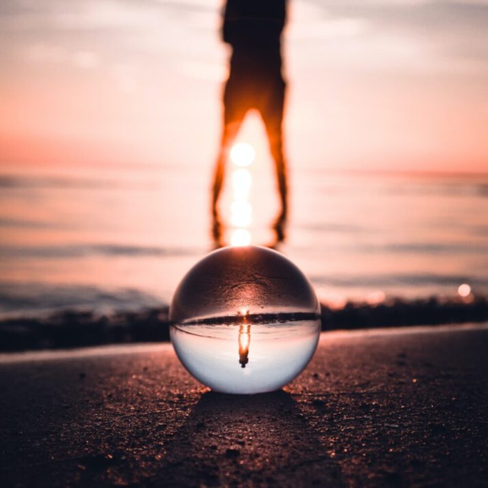 effektvolles Bild einer Person am Strand deren Beckenregion die Abendsonne erhellt