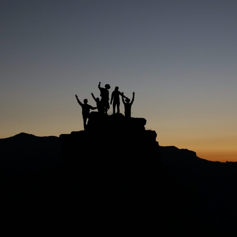 Eine Gruppe junger Menschen stehen auf einem Berg