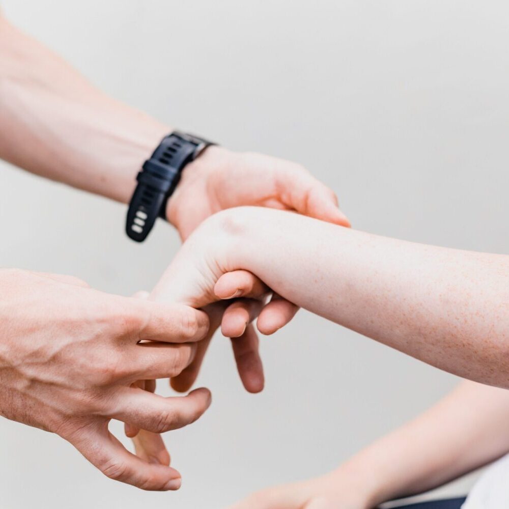 Therapeut:in Testet die Beweglichkeit des Handgelenkes